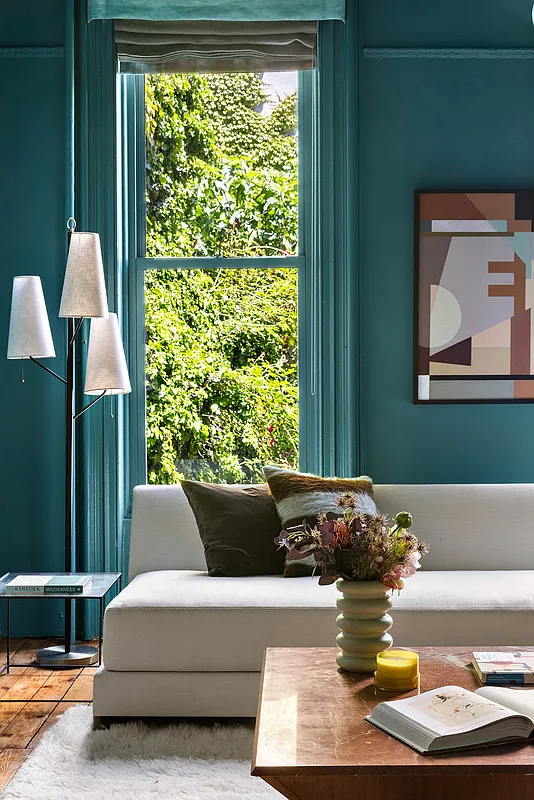 detail of rear parlor with green walls and white sofa
